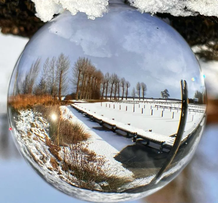 Glaskugel-Fotografie: Der verschneite Anleger im Fokus der Kugel
