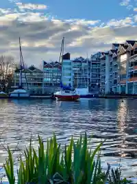 Wohnanlage Am Delf vom Wasser aus gesehen, mit Booten im anliegenden Hafen