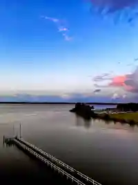 Sanfter Sonnenuntergang mit farbigen Wolken über dem See und Hafen