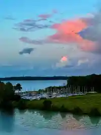 Intensiv pink leuchtende Wolken bei Sonnenuntergang über dem Hafen