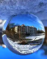 Glaskugel-Fotografie: Die winterliche Wohnanlage steht in der Kugel Kopf