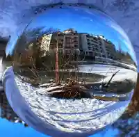 Glaskugel-Fotografie: Eine weite Winterlandschaft mit Bäumen am gefrorenen See