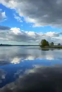 Wunderschöne Wolkenformationen spiegeln sich im ruhigen Wasser des Sees