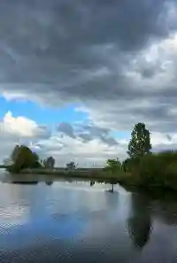 Weiter Blick über den See auf den fernen Yachthafen Bünting unter blauem Himmel
