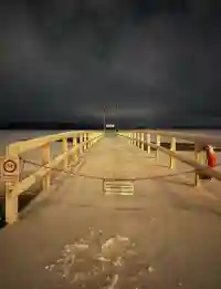 Verschneiter Steg (Eyhausen) in den See bei Nacht mit Sperrschildern