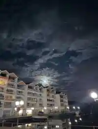 Der helle Vollmond scheint durch die Wolken über der nächtlichen Wohnanlage