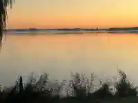 Mystischer Morgennebel steigt bei Sonnenaufgang über dem See auf